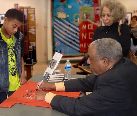 Freedom Rider Bernard Lafayette signs a t-shirt for a student at the Freedom Rides Museum